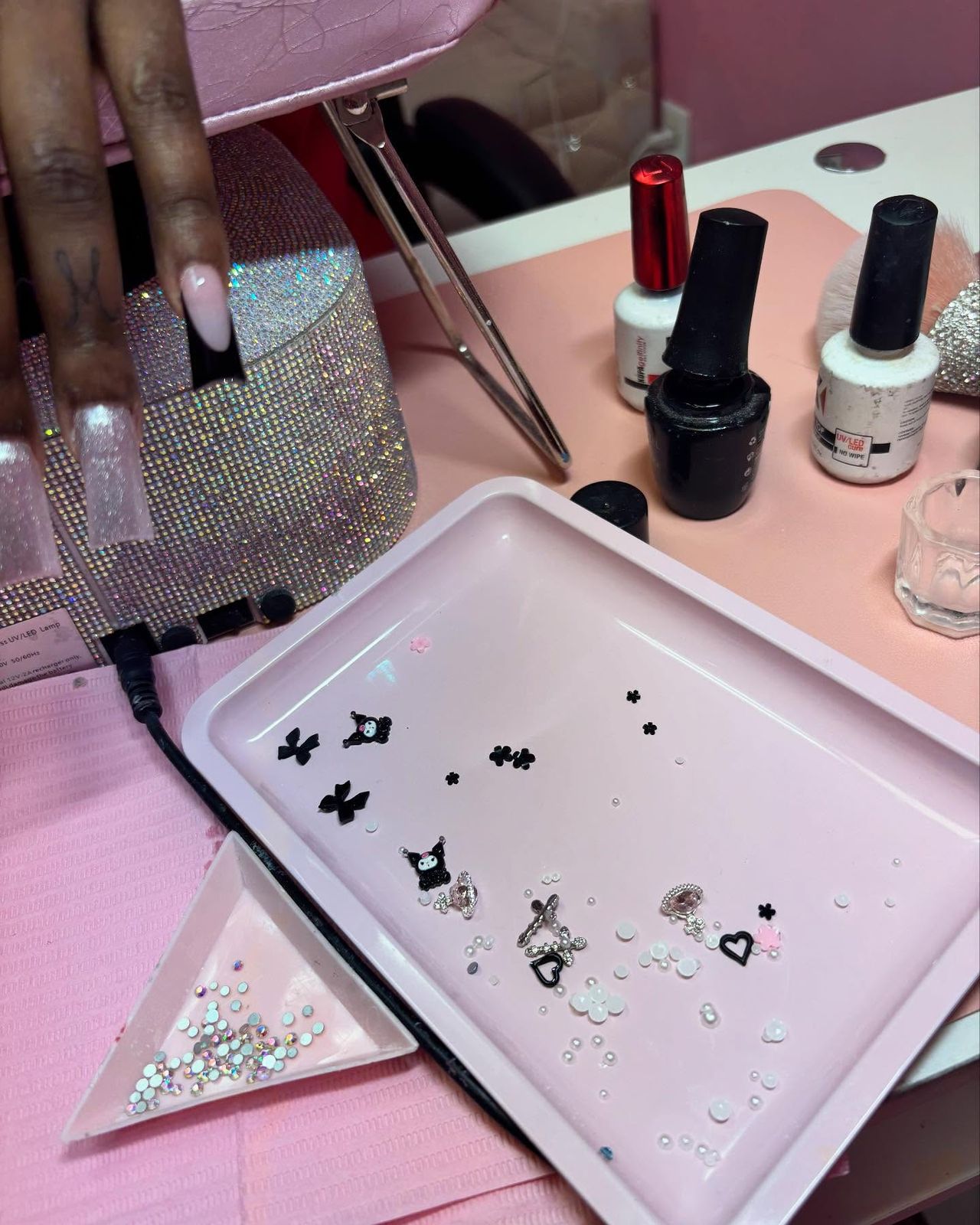 Nancy's workstation with gel polish and a tray of charms